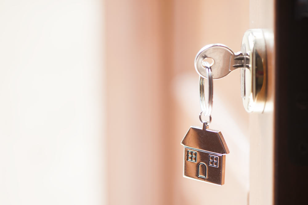 A key in a door with a home key chain on it