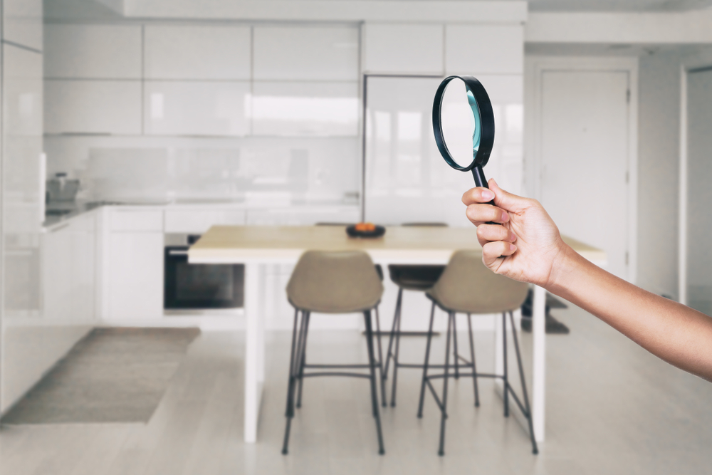 Home inspection looking at a kitchen with a magnifier glass