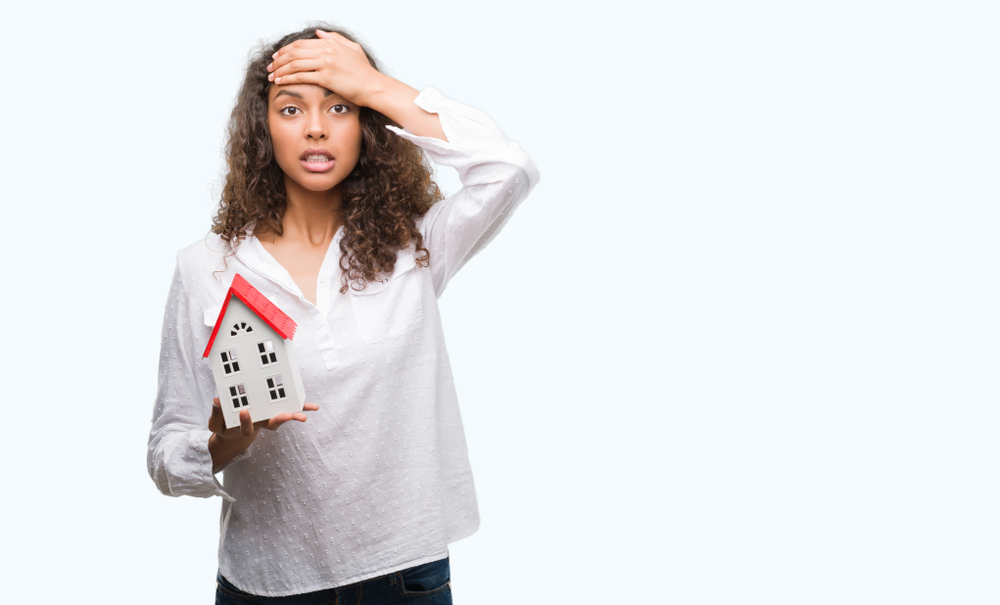 A woman holding a home with a stressed look on her face